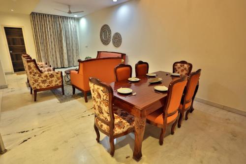 a dining room with a wooden table and chairs at Aravali Villa Homestay with Rooftop Jacuzzi in Udaipur