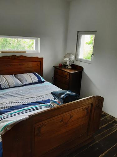 um quarto com uma cama de madeira e uma janela em La Graule Old Farmhouse Studio 1 room em Saint-Colomb-de-Lauzun