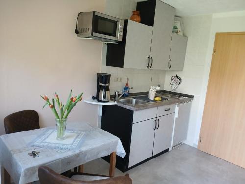 une petite cuisine avec une table et un micro-ondes dans l'établissement Haus Stefanie, à Heringsdorf