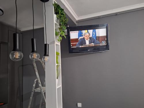 einen TV an der Wand im Wohnzimmer in der Unterkunft MAGIC ROOM HUNEDOARA in Hunedoara