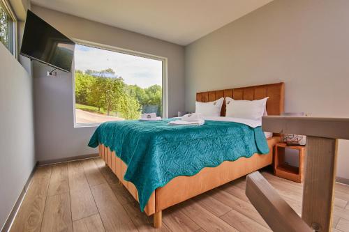 a bedroom with a bed with a large window at Copper's Kub in Slănic-Moldova