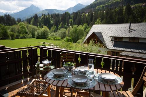 a table on a balcony with a view of the mountains at La Casa di Carmen in Tarvisio