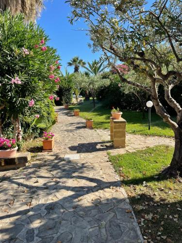 a stone walkway with plants and flowers in a park at Soleada Club in Campofelice di Roccella