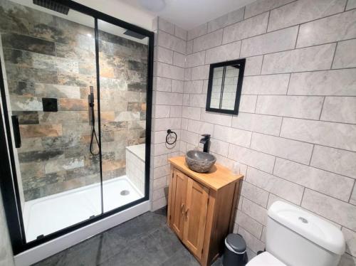 uma casa de banho com um chuveiro, um WC e um lavatório. em Nelson By The Docks Serviced Apartments by Roomsbooked em Gloucester