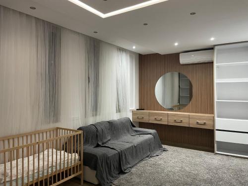ein Schlafzimmer mit einem Kinderbett und einem Spiegel in der Unterkunft Magnifique Villa in Beni Mellal