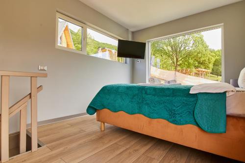 a bedroom with a bed and a large window at Copper's Kub in Slănic-Moldova