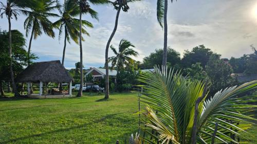 a park with palm trees and a gazebo at SANJEELA-PLAGE COCO in Diego Suarez