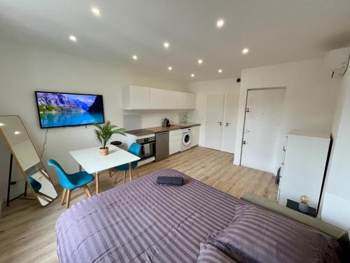 a bedroom with a bed and a table and a kitchen at Masha *CLIM* proche hospital in La Tronche