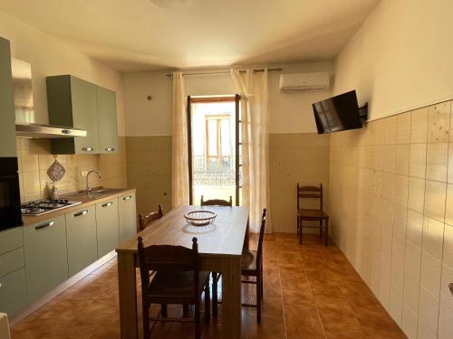 eine Küche und ein Esszimmer mit einem Tisch und Stühlen in der Unterkunft Gli agrumi di Nonna Peppina - Appartamento Limoni in Mondragone