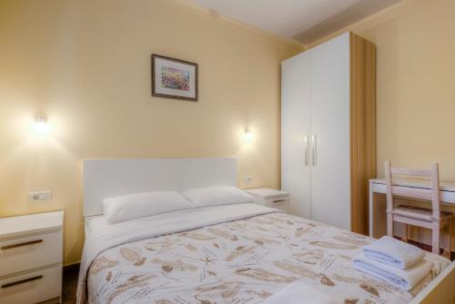 a bedroom with a bed and a desk with towels on it at Villa Moletto Apartments with Sea view in Lovrečica