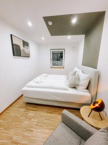 a white bedroom with a bed and a couch at DoreyHome P3 - Modernes charmantes Apartment in Passau