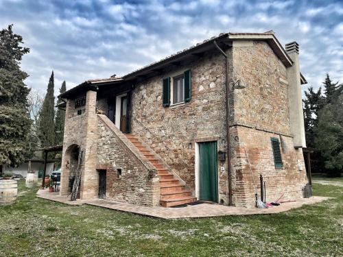 ein Steinhaus mit einer Seitentreppe in der Unterkunft Montebello degli Olivi in Chiusi