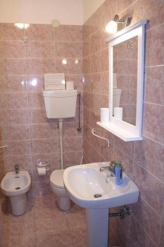 bagno con lavandino, servizi igienici e specchio di Nice Apartment in Taormina a Taormina