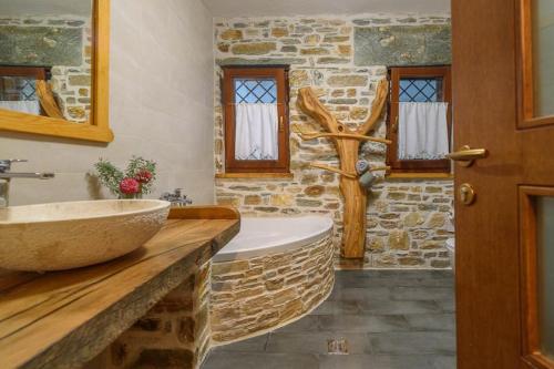 a stone bathroom with a tub and a sink at The Stone House in Líri