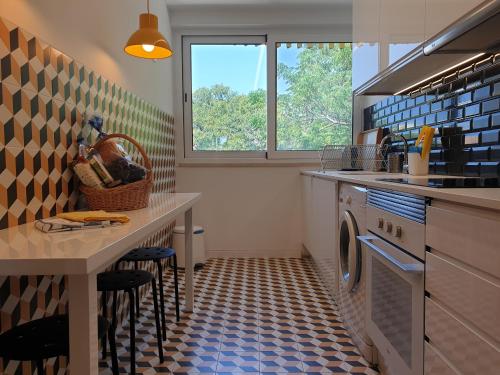 ヴィラモウラにあるQuinta Do Romãoのキッチン(洗濯機、テーブル、スツール付)