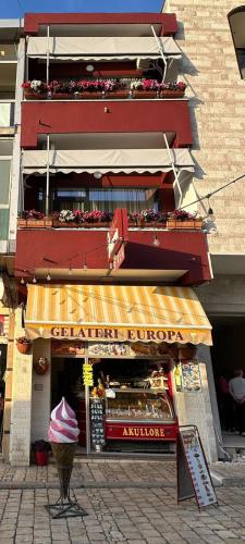 a store with a yellow awning in front of a building at Hotel Europa Kruje in Krujë