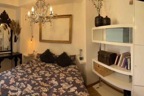 um quarto com uma cama e um lustre em Wifi terraza aire acondicionado em Tafalla