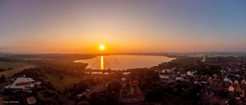 una vista aerea di un lago al tramonto di Ferienhaus Beerster Sonne am See Ideal for a long stay Netflix a Bad Bederkesa