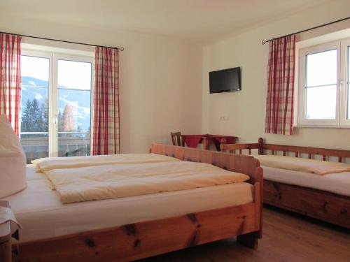 - une chambre avec 2 lits, une télévision et des fenêtres dans l'établissement Reitercamp Ortnerhof, à Ramsau am Dachstein