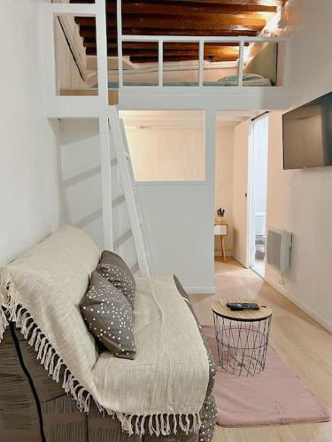 Cette chambre comprend une mezzanine avec un canapé et une table. dans l'établissement Appartement au centre de Paris, à Paris