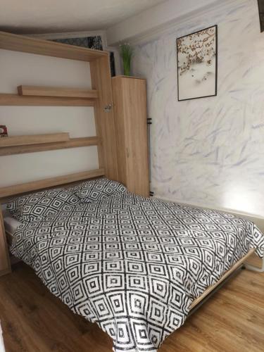 sypialnia z łóżkiem z czarno-białą kołdrą w obiekcie Przylesie Dom Turystyczny w Ostródzie