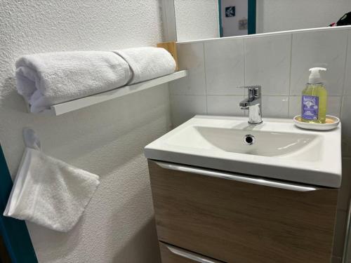 une salle de bain avec un lavabo, un miroir et des serviettes dans l'établissement Délicieux Studio 3 p climatisé La Faviere, à Bormes-les-Mimosas