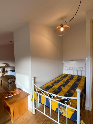 a small bedroom with a bed and a table at Les Chambres des 3 Chouettes in Sepx