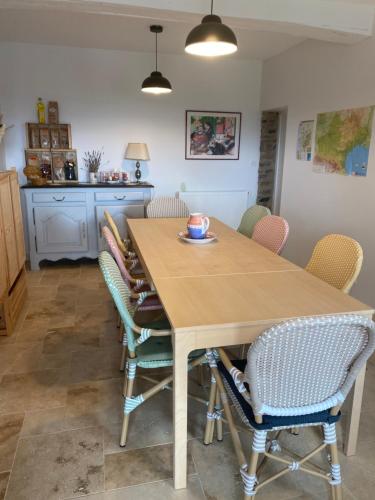 a dining room with a wooden table and chairs at Les Chambres des 3 Chouettes in Sepx