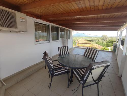 ein Esszimmer mit einem Tisch und Stühlen auf dem Balkon in der Unterkunft INFO στούντιο in Messini