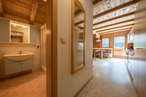 a bathroom with a sink and a kitchen with a table at Gasthof Innerwalten in San Leonardo in Passiria