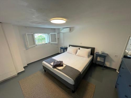 a bedroom with a bed and two tables and a window at Spanos Suites - Panteli in Panteli