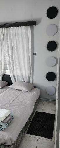 - une chambre avec un lit avec un rideau et une fenêtre dans l'établissement JIM, à Andravída