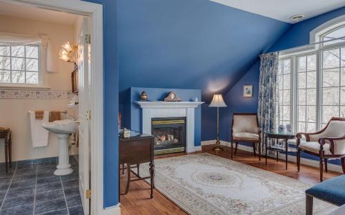 a living room with blue walls and a fireplace at Manoir Sweetsburg in Cowansville