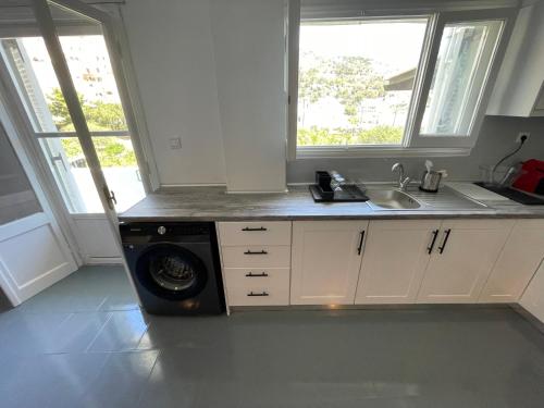 a kitchen with a sink and a washing machine at Spanos Suites - Panteli in Panteli