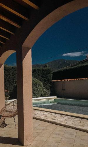 une maison avec une piscine et une chaise dans l'établissement Villa entre mer et montagne, à Villelongue-dels-Monts