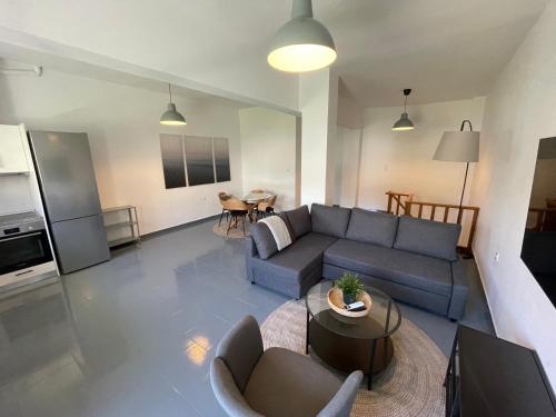 a living room with a blue couch and a table at Spanos Suites - Panteli in Panteli