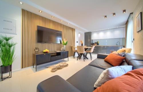 sala de estar con sofá y TV grande en Apartments Sinisa - Krk Town en Krk