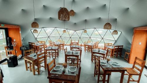 an empty restaurant with wooden tables and chairs at Glamping Puente Blanco in Sierra de la Ventana