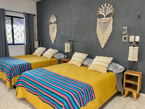 2 camas en una habitación con cabeceros en la pared en Itzé Hostel Boutique - Progreso, en Progreso