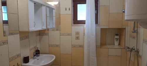 baño con lavabo y ventana en Mókusles Vendégház, en Háromhuta