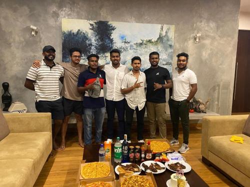 a group of men posing for a picture in a living room at Thalangama Lakeview Lodge in Battaramulla