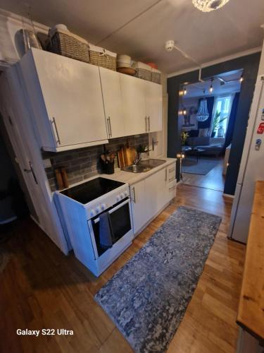 a kitchen with white cabinets and a blue stove top oven at Sjarmerende leilighet i hjerte av Tønsberg by in Tønsberg