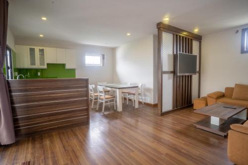 ein Wohnzimmer und eine Küche mit einem Tisch und einem Sofa in der Unterkunft Mai Khanh Hotel in Da Lat