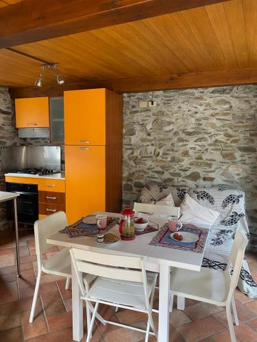 a table and chairs in a kitchen with a stone wall at Il Nido di Ronco in Nonio