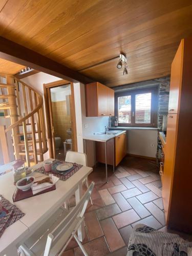 a kitchen with a table and a sink in a room at Il Nido di Ronco in Nonio