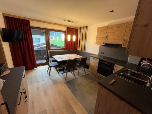 a kitchen with a table and chairs in a room at Appartement Gästehaus Aloisia in Hippach