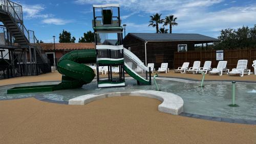 a pool with a water slide in a resort at Mobil homme proche de la mer in Le Grau-du-Roi