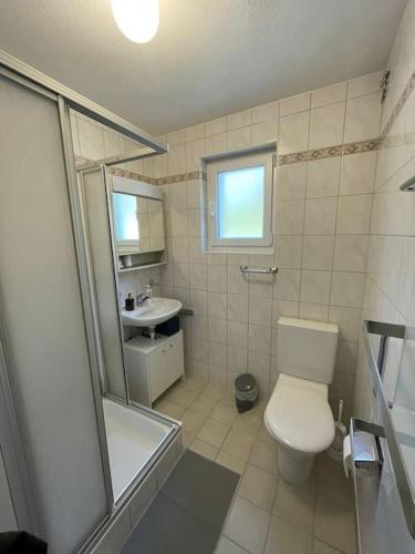 a white bathroom with a toilet and a sink at Maison pour des vacances in Ayent