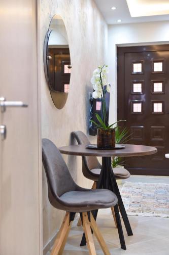 a table with two chairs and a mirror in a room at Vila Apartments Lidija in Petrovac na Moru