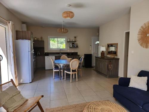 Il comprend un salon et une cuisine avec une table et des chaises. dans l'établissement Charmante maison à 2 pas du lac de Biscarosse, à Biscarrosse